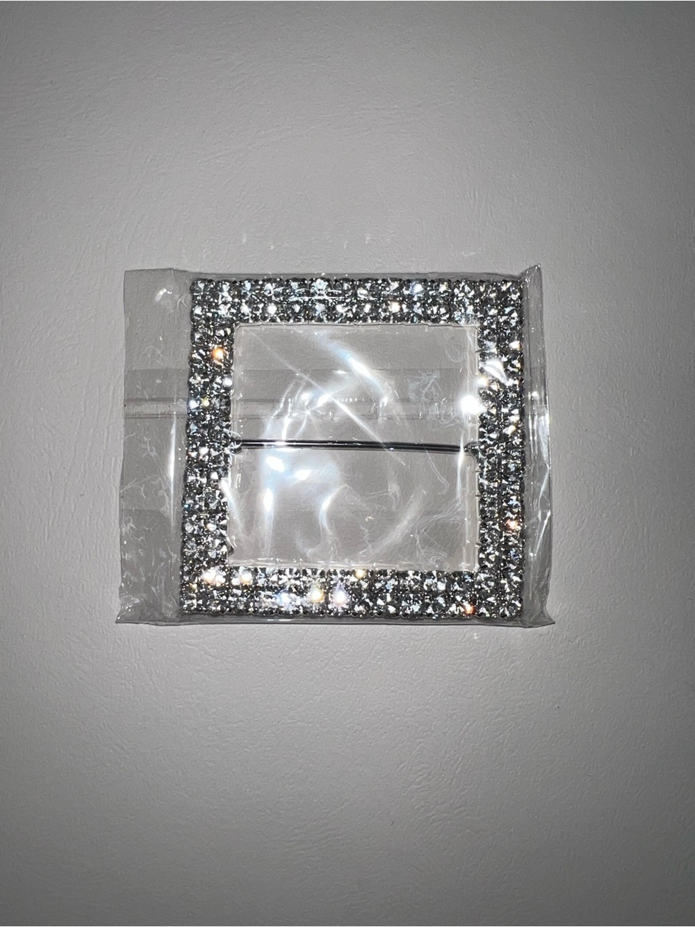 Silver rhinestone buckle with square frame and glittery embellishments